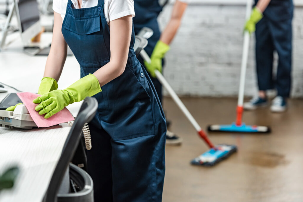 cropped-view-of-cleaner-wiping-phone-while-colleag-2024-11-18-03-23-39-utc